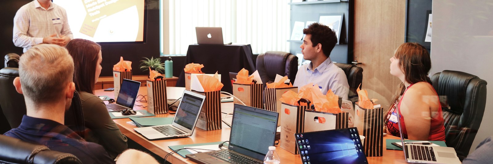 Trainer presenting to participants at a functional safety training with laptops